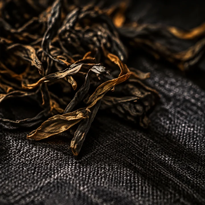Long dark Mi Lan Xiang Dan Cong oolong leaves on dark linen